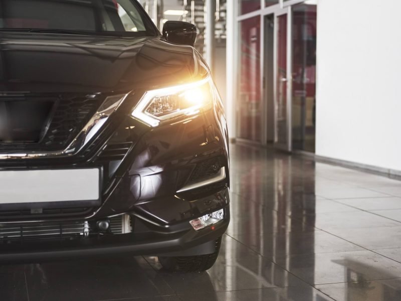 the-headlights-and-the-hood-of-a-black-luxury-car.jpg